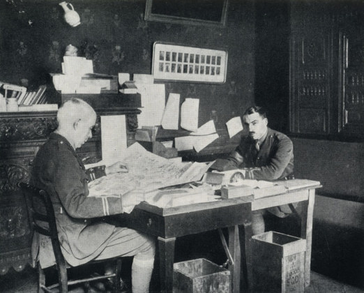 C.E. Montague (links) an seinem Schreibtisch, 1918
