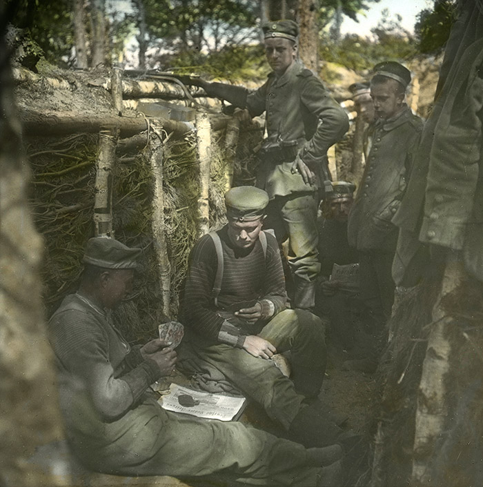 Deutsche Soldaten spielen Karten in einem Schützengraben